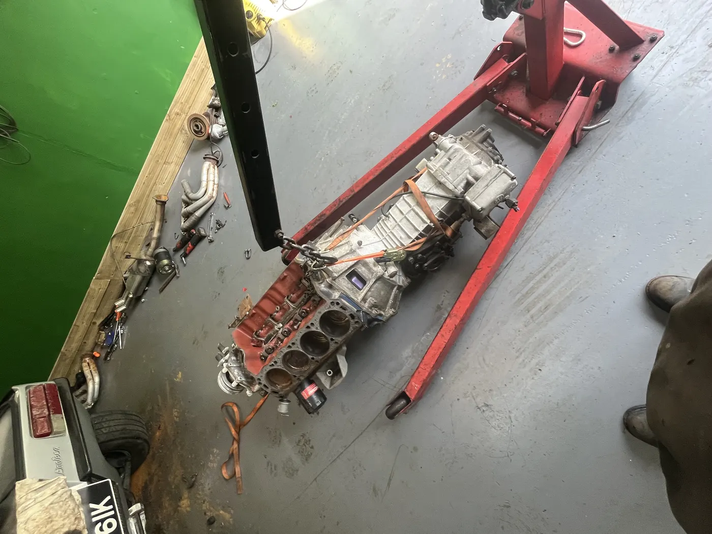Engine and gearbox on crane during restoration at Goblin Automotive
